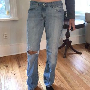 vintage well worn soft Levi’s 505 blue jeans with natural rip at the left knee